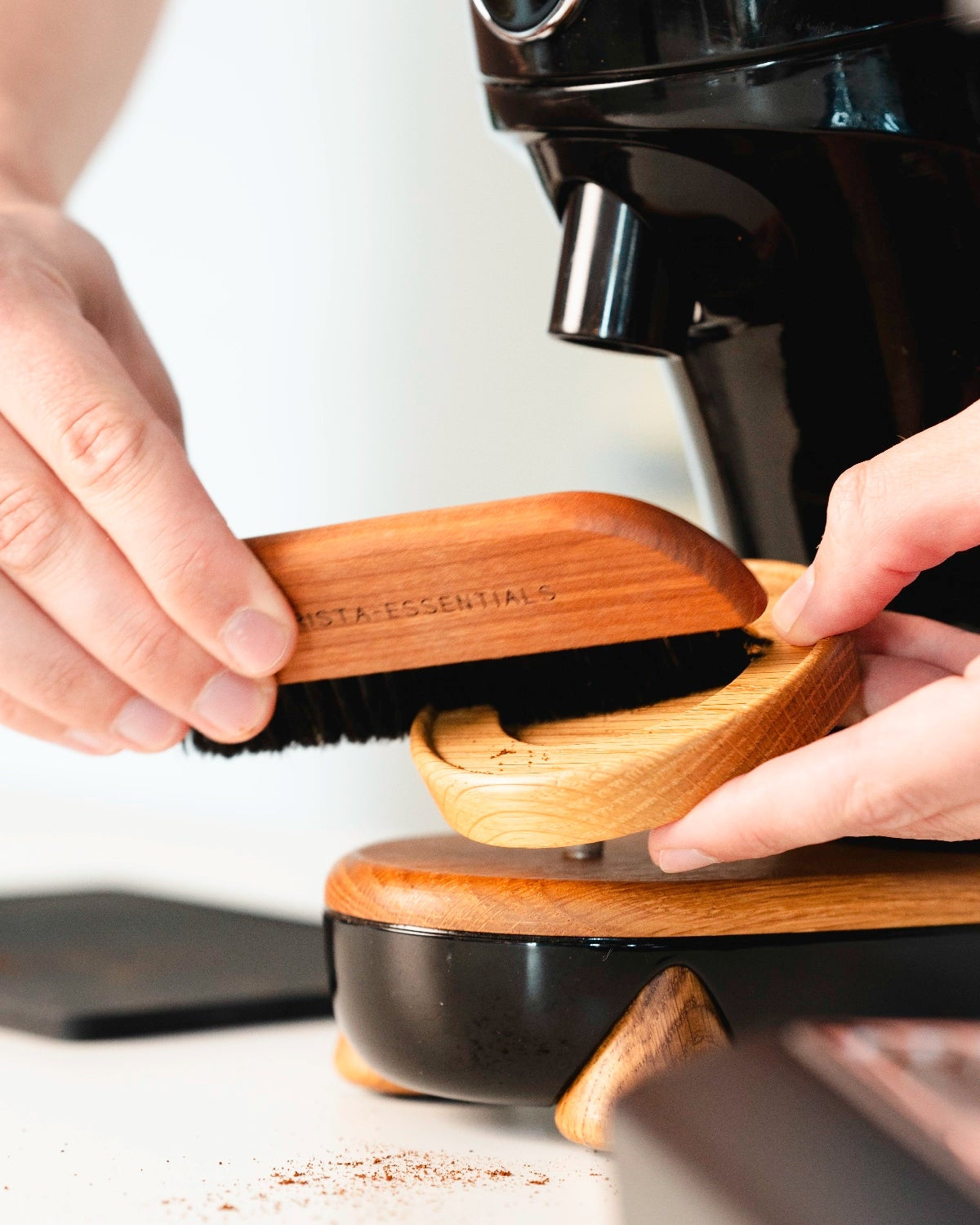 Koffieborstel in gebruik om rondom je bonenmaler op te ruimen