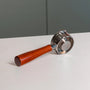 Naked portafilter met houten handvat en convex filterbakje 58mm op tafel